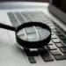A magnifying glass looking at a laptop keyboard
